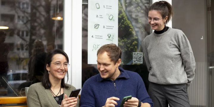 Ulrike, Moritz und Fenia schauen gemeinsam auf die 2zero App.